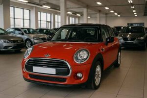 Mini Cooper bekas warna merah sedang dipajang di showroom mobil bekas, siap dijual dengan harga lebih terjangkau